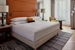 una camera da letto con un grande letto bianco con testiera marrone di Paris Marriott Champs Elysees Hotel a Parigi