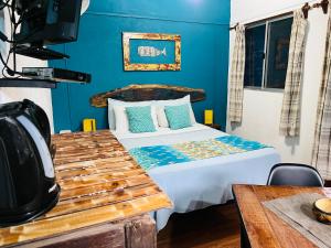 1 dormitorio con cama y pared azul en Altillo Valizas, en Barra de Valizas