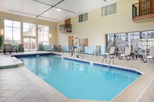 a large pool in a hotel room with chairs and tables at Best Western Circus City Inn in Peru