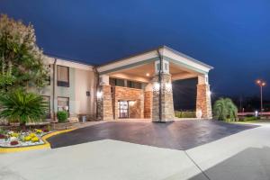 a large building with a courtyard at night at Best Western Bayou Inn in Westwego