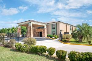 a house with a gate in front of a driveway at Best Western Bayou Inn in Westwego