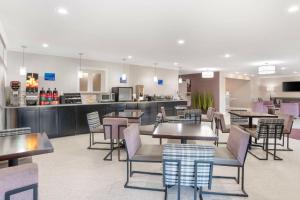 a restaurant with tables and chairs and a counter at Best Western Bayou Inn in Westwego