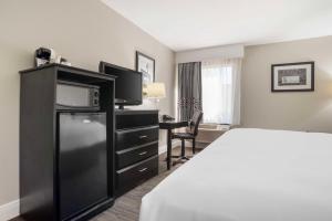 a hotel room with a bed and a flat screen tv at Best Western Bayou Inn in Westwego +19 photos
