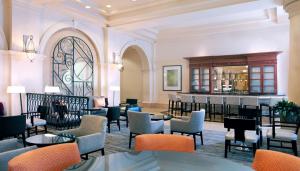 a restaurant with tables and chairs and a bar at Hilton Naples in Naples