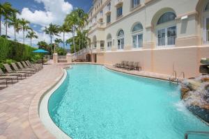 a swimming pool in front of a building at Hilton Naples in Naples
