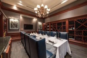 a dining room with a long table and a chandelier at Hilton Naples in Naples