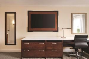 an office with a desk and a television on the wall at Hilton Naples in Naples