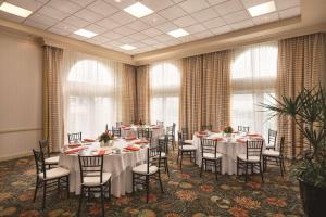 a conference room with tables and chairs and windows at Hilton Naples in Naples