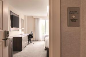 a hotel room with a bed and a desk at Hilton Naples in Naples
