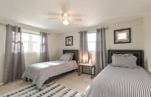 a bedroom with two beds and a ceiling fan at IVP Manor House By LAKE BEACH and NAVAL BASE in Gages Lake