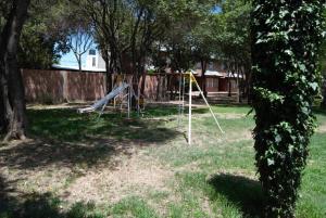 un columpio en un patio con árboles en Complejo Arco Iris en Villa Cura Brochero