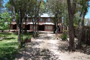 a house in the middle of a forest of trees at Complejo Arco Iris in Villa Cura Brochero