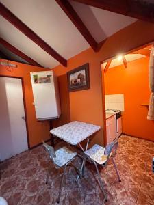 a kitchen with a table and chairs and a refrigerator at CABAÑAS RINCON CHILENO in Monte Grande