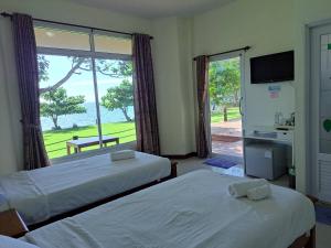 een slaapkamer met 2 bedden en een groot raam bij Lomtalay Resort Trat in Ban Bang Pit Lang
