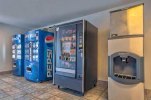 uma máquina de refrigerantes e um refrigerador de bebidas numa loja em Motel 6-Farmington, NM em Farmington