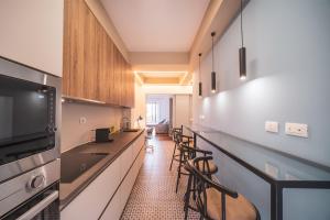 una cocina con una barra larga con taburetes en St. Peter Twilight BuddyRent, en Roma