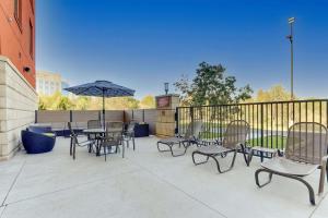 a patio with chairs and tables and an umbrella at Drury Inn & Suites Independence Kansas City in Blue Springs