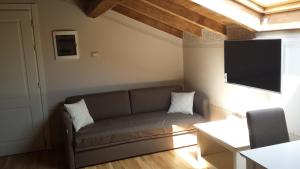 Una sala de estar con un sofá y un televisor de pantalla plana. en Hotel Sesmones, en Lodi