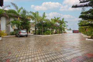 a car parked on a cobblestone street with palm trees at Luxurious Estate in Takoradi