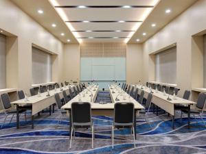 une grande salle de conférence avec des tables et des chaises dans l'établissement Grand Mercure Lampung, à Bandar Lampung