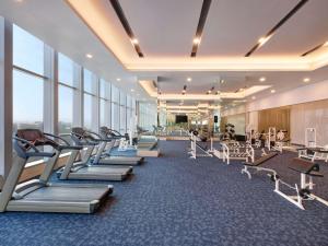 une salle de sport avec une rangée de tapis de course et de machines dans l'établissement Grand Mercure Lampung, à Bandar Lampung