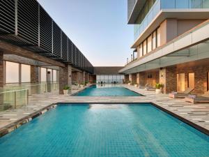 une image de deux piscines dans un bâtiment dans l'établissement Grand Mercure Lampung, à Bandar Lampung