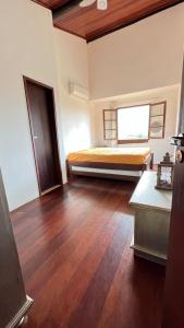 a bedroom with a bed and a wooden floor at FLAT GRAVATÁ WINTERVILLE 1214 in Gravatá