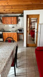 una cocina con mesa y una cocina con refrigerador en Alojamientos ANSAI 1, en El Bolsón