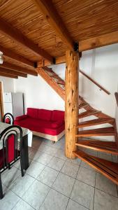 sala de estar con sofá rojo y escaleras en Alojamientos ANSAI 1, en El Bolsón