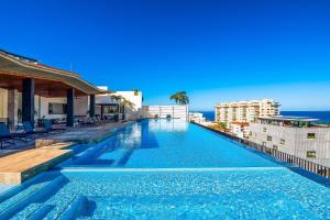 a swimming pool on top of a building with the ocean in the background at Madero 320 - 310 in Puerto Vallarta