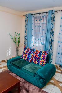 a couch with two pillows on it in a living room at A&B Cozy Retreat Kitale in Kitale