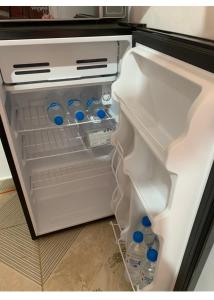 een open koelkast met flessen water erin bij Caribbean Domicile in Las Terrenas