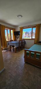 ein Zimmer mit zwei Betten und einem Tisch und einem Fernseher in der Unterkunft Departamentos Mirador del Maipú in San Martín de los Andes