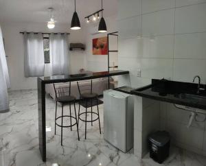 a kitchen with a counter and bar with stools at Casa Nova no Centro de Penedo in Penedo