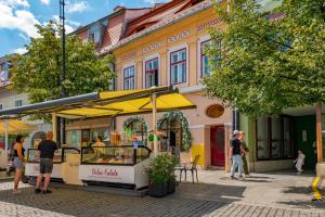 people standing in front of a food cart on a street at Apartment Balcescu No 10 in Sibiu