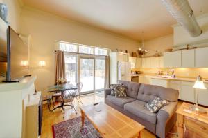 a living room with a couch and a table at Charming Saugatuck Condo with Private Deck and Grill! in Saugatuck