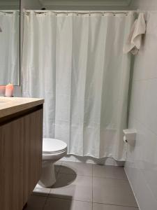 a bathroom with a toilet and a shower curtain at Arriendo diario departamento completamente amoblado in Iquique