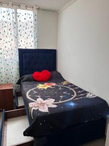 a bedroom with a bed with a red pillow on it at Arriendo diario departamento completamente amoblado in Iquique