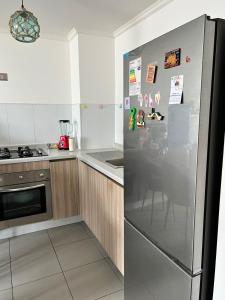 a kitchen with a stainless steel refrigerator and a stove at Arriendo diario departamento completamente amoblado in Iquique
