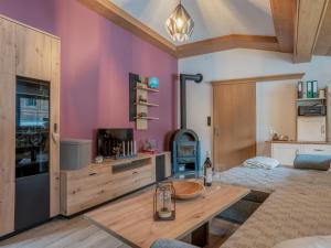 sala de estar con paredes de color púrpura y mesa de madera en Blumenwiese, en Kelchsau