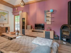 1 dormitorio con paredes rosas, 1 cama y chimenea en Blumenwiese, en Kelchsau