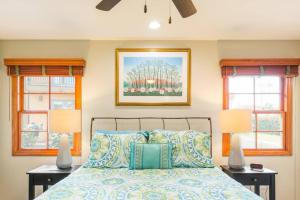 a bedroom with two windows and a bed with pillows at The Little Pumpkin Guest House in San Diego