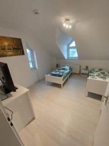 a attic room with two beds and a tv at Reinfeld Zentral in Reinfeld