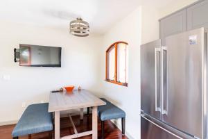 een keuken met een houten tafel en een koelkast bij The Little Pumpkin Guest House in San Diego
