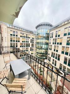 een balkon met een tafel en stoelen en gebouwen bij Spacious 2BDR apartment with balcony in Wenceslas Square in Praag