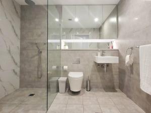 a bathroom with a shower and a toilet and a sink at Modern Elegance: 2 Bedroom Oasis w/ Free Parking in Epping