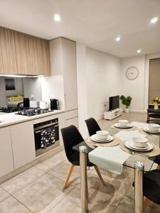 cocina con mesa y sillas en una habitación en Modern Elegance: 2 Bedroom Oasis w/ Free Parking, en Epping