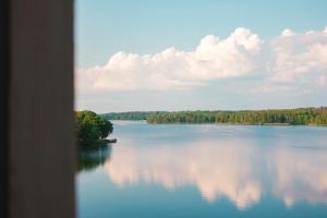 uma vista para um grande lago com árvores e nuvens em Lejondals Slott em Bro