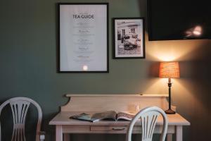 a desk with two chairs and a table with a book at Lejondals Slott in Bro