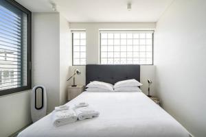 a bedroom with a large white bed with two towels on it at EIGHT TWO NINE TWO IV: BONDI BEACH in Sydney